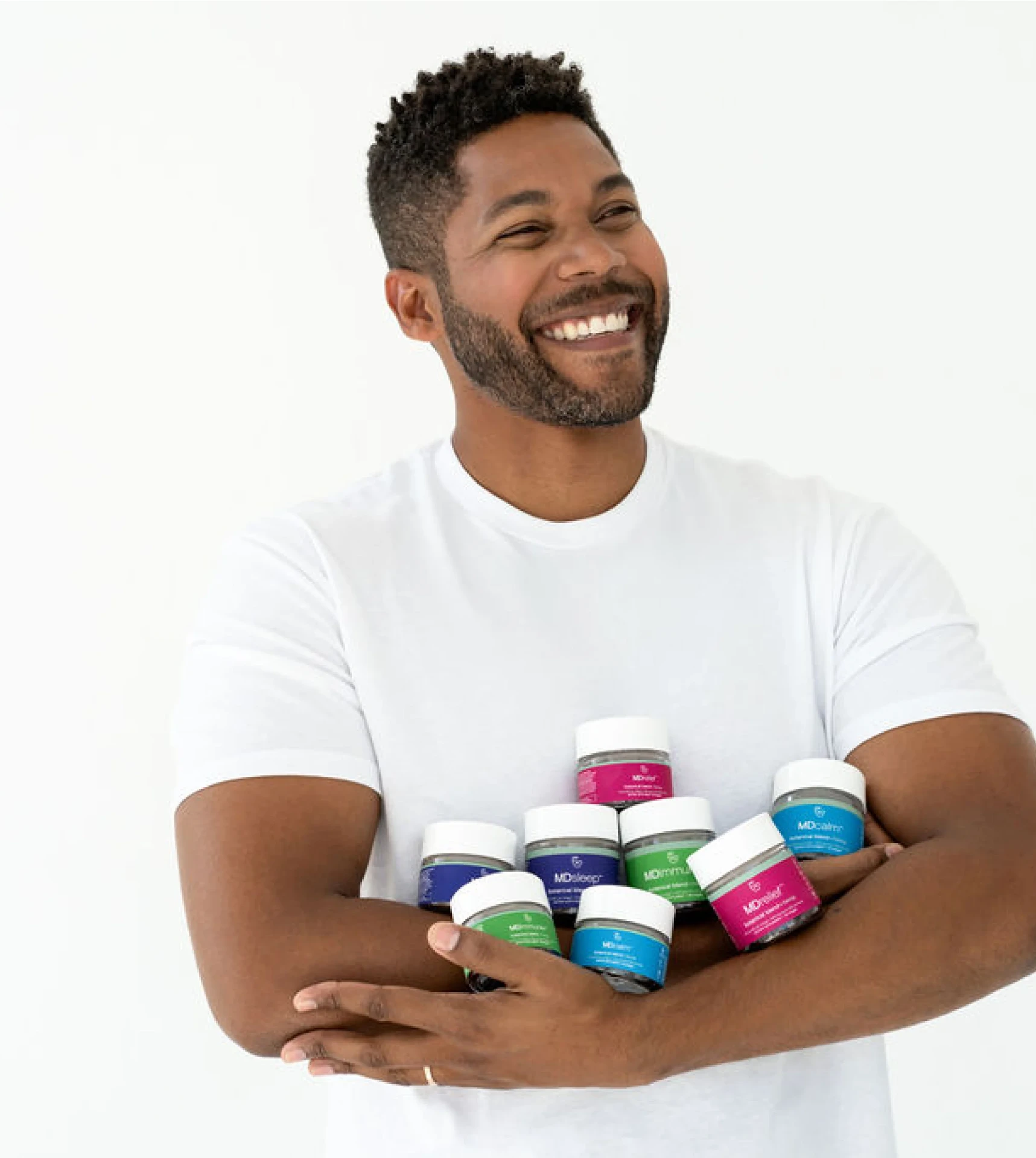 a young man smiling holding sleep aids products in his arms a young man smiling holding sleep aids products in his arms