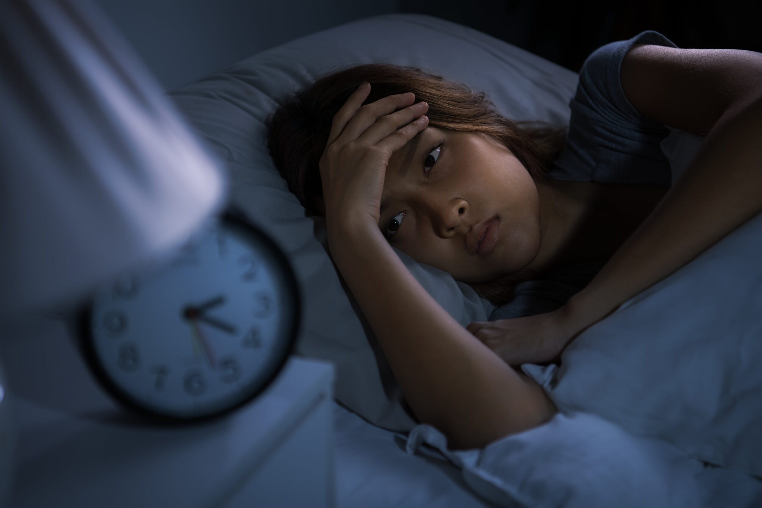 mujer_intentando_dormir woman in her bed watching the clock and trying to sleep