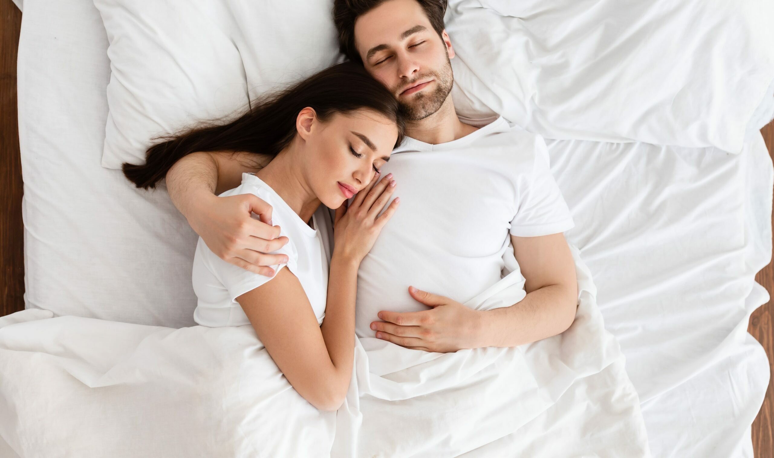pareja_durmiendo husband and wife in their bed with white sheets sleeping embraced