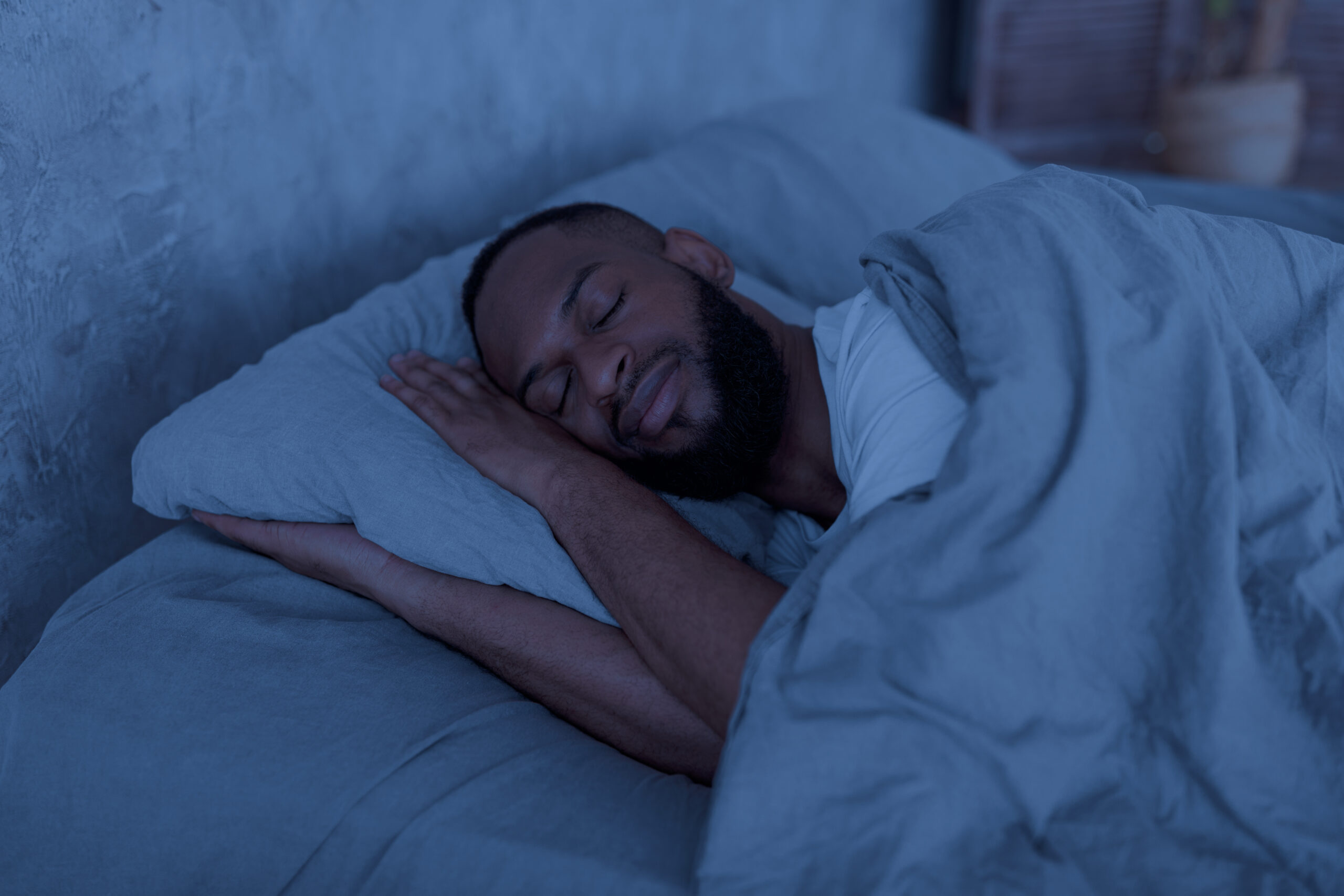 man sleeping soundly in his bed