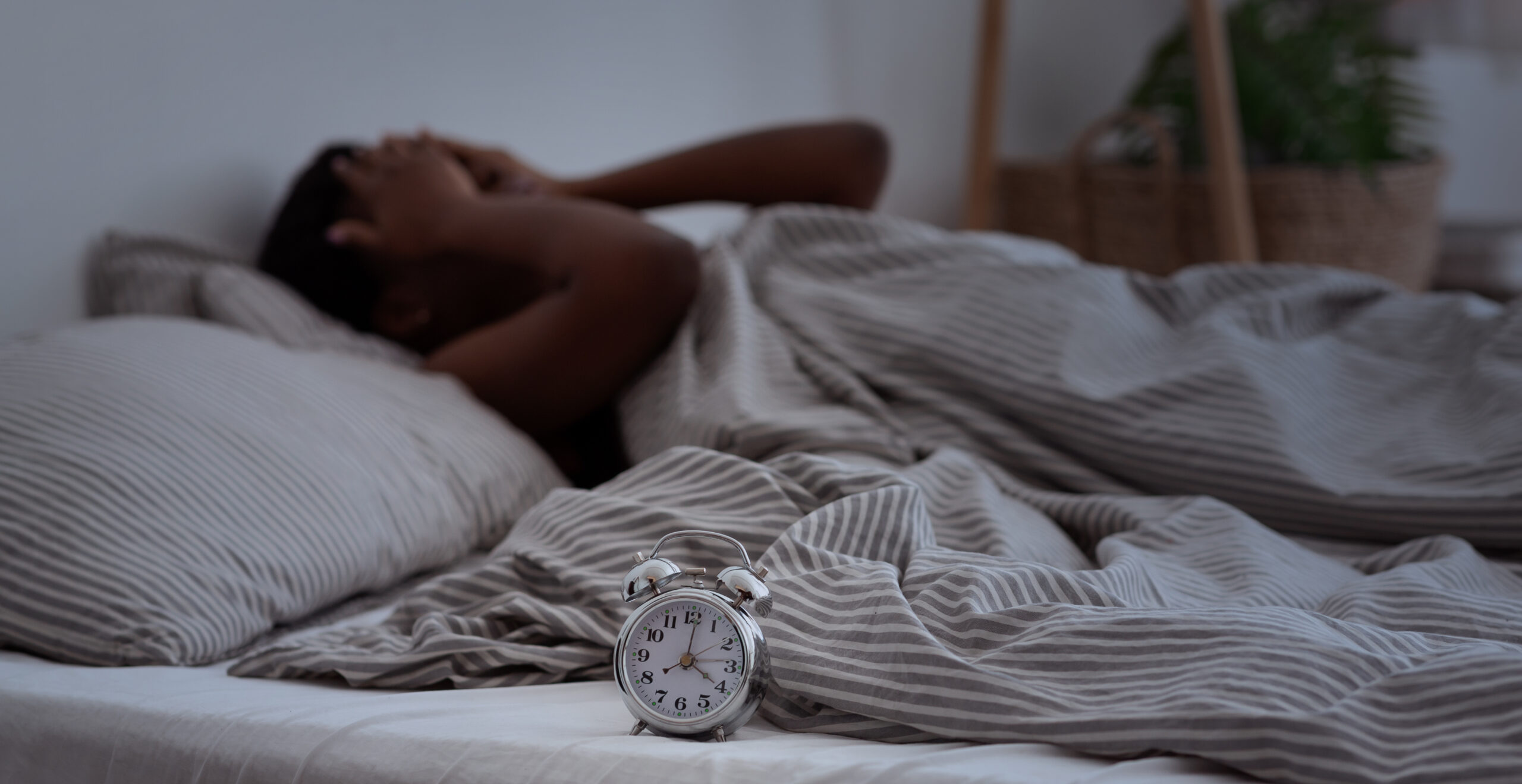 Sleepless, woman suffering from insomnia, sleep apnea or stress, headache or migraine woman unable to sleep in her bed