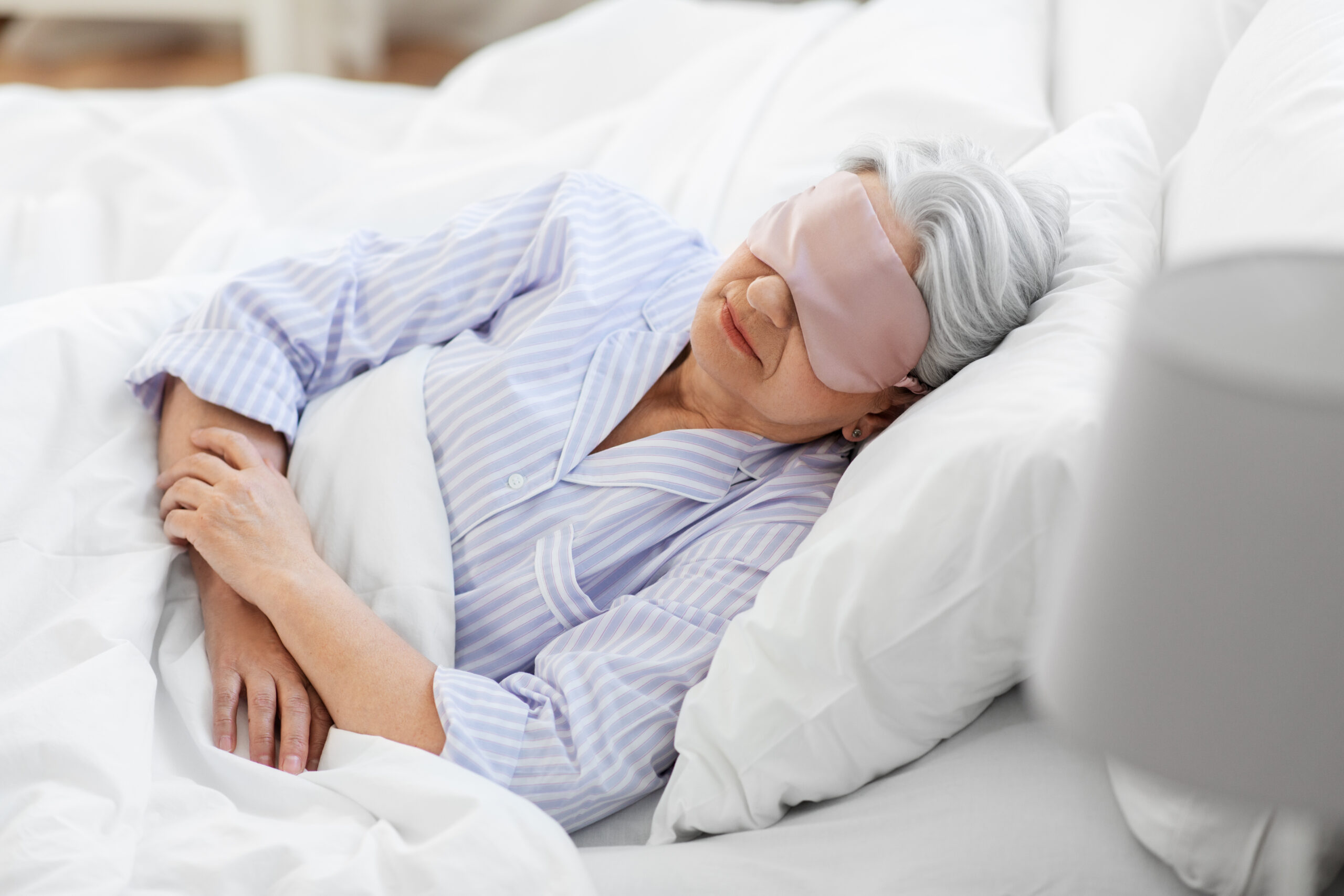 senior woman with eye mask sleeping in bed at home Grandmother sleeping in her bed with a sleep mask