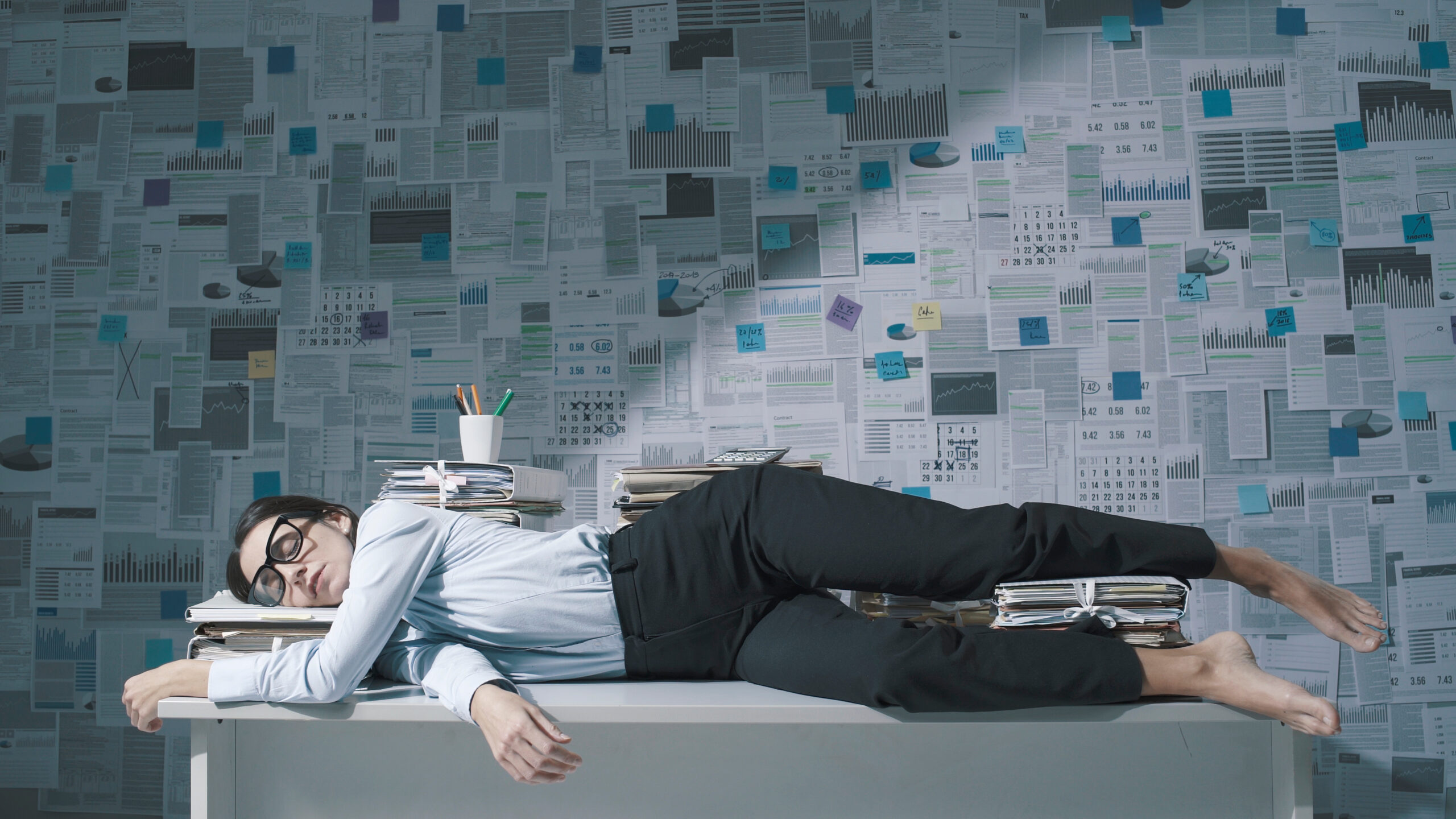woman sleeping soundly on top of her desk
